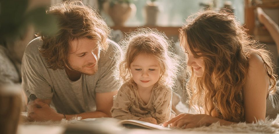 Eltern lesen mit kleinem Kind ein Buch – Kinderbuch zur IVF-Aufklärung von Glanzfunke