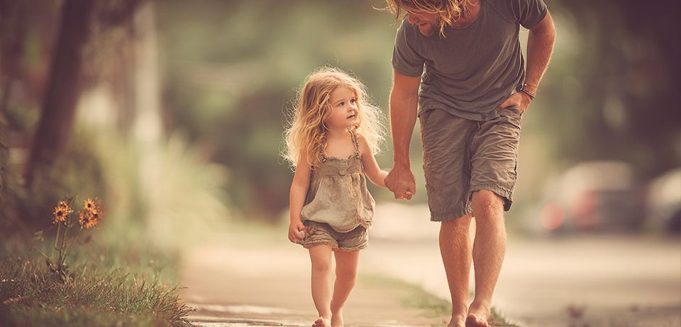 Vater und Kind spazieren Hand in Hand – Familienleben nach IVF-Naturelle® Kinderwunschbehandlung